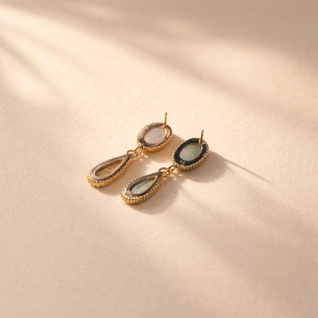 A back view of Ruinette one-of-a-kind-earrings featuring white and black opal, green and peach tourmaline, set in 18k yellow gold