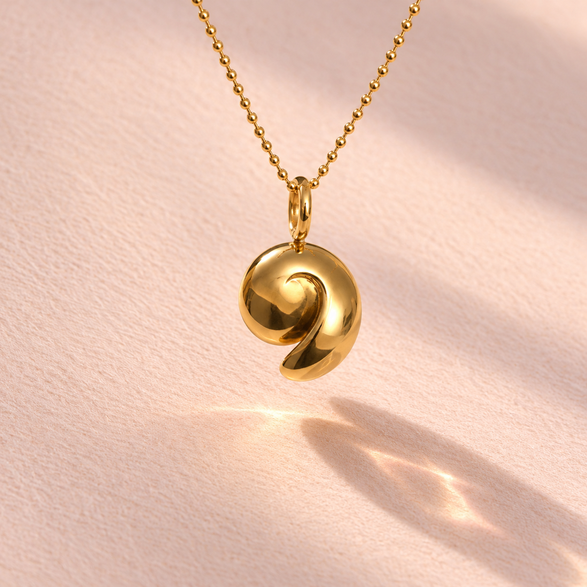 18k yellow gold charm inspired by an ammonite nautilus shell, epitomizing Ruinette Bijoux's artisan craftsmanship.