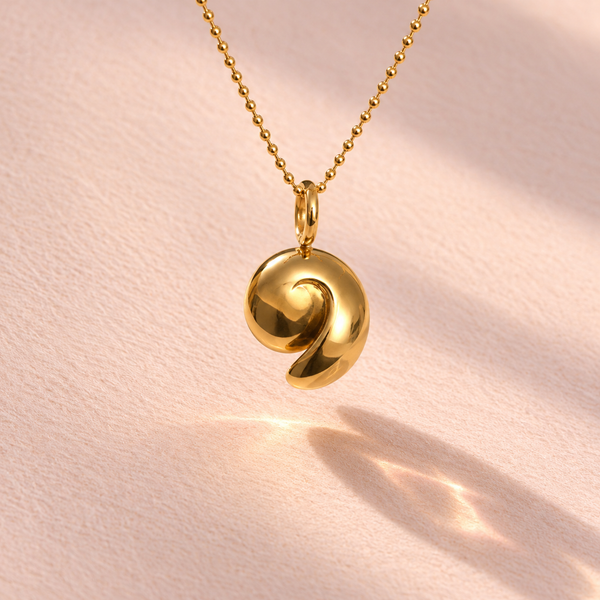 18k yellow gold charm inspired by an ammonite nautilus shell, epitomizing Ruinette Bijoux's artisan craftsmanship.