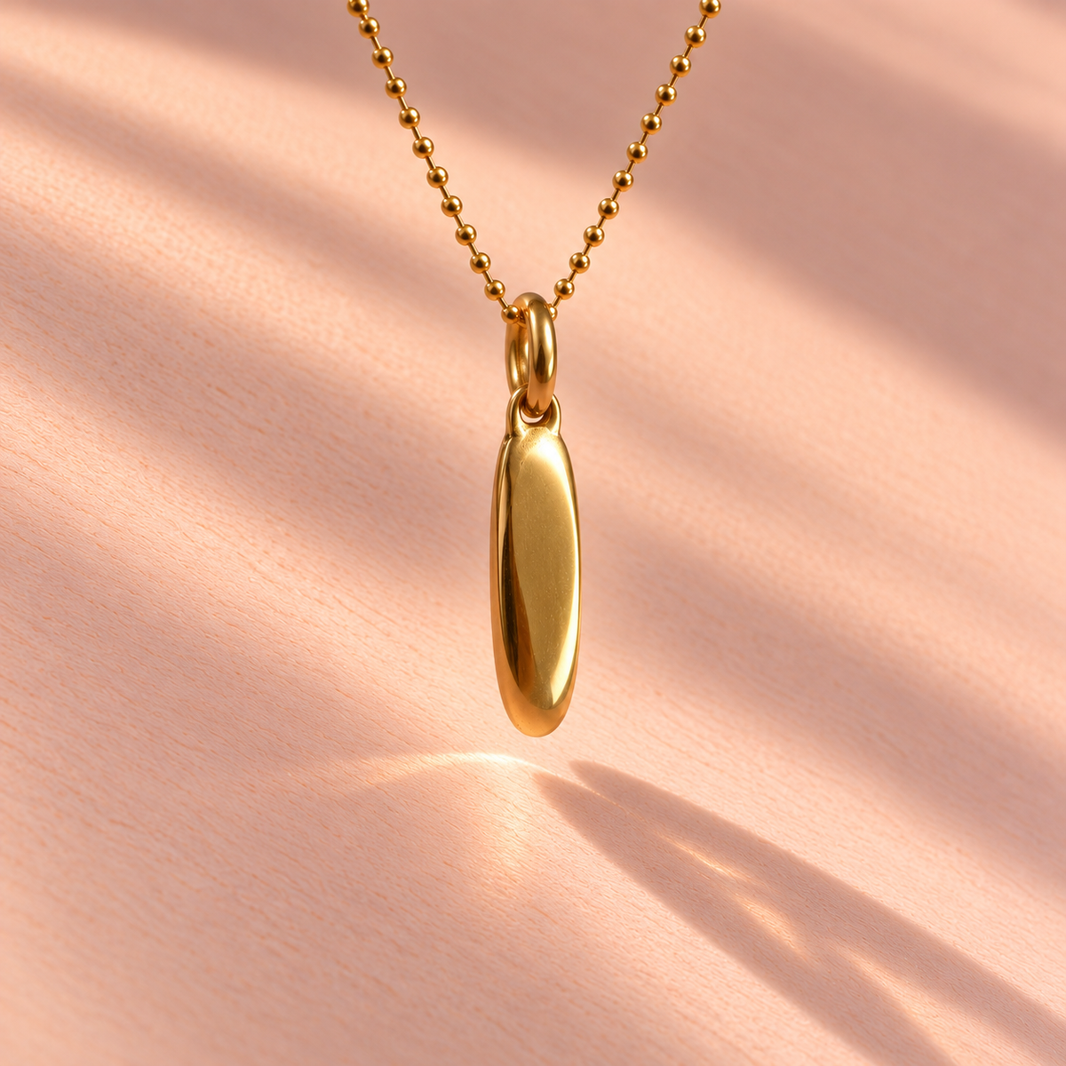 Back view of an 18k yellow gold charm from the Ruinette Bijoux Girl Dinner collection, showcasing elegant simplicity in fine jewelry.