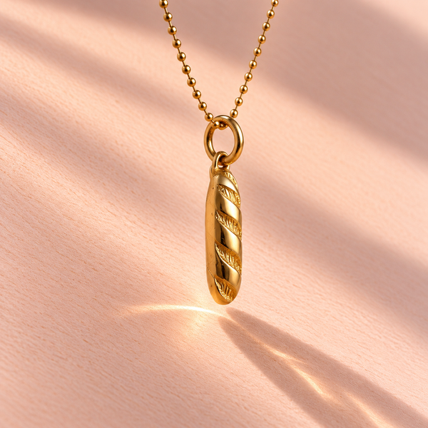 The Baguette Charm side view showcases the 18k yellow gold craftsmanship, part of Ruinette Bijoux's enticing Girl Dinner collection.
