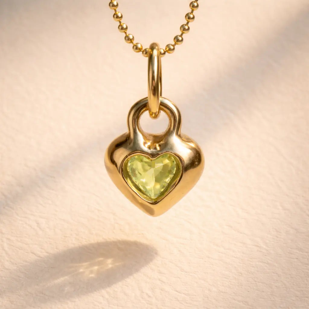 Back view of Ruinette Becky Peridot Heart Charm showing heart-cut peridot stone set in polished 18k gold pendant with bail and ball chain necklace