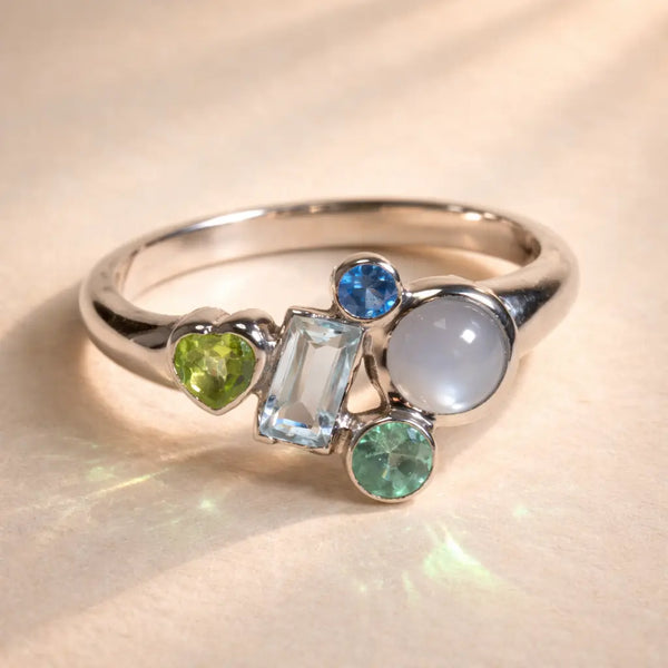 Ruinette Constellation Ring 1 with a 18k white gold band with a cluster of five gemstones in Sapphire, Aquamarine, Gray Moonstone, and Peridot.