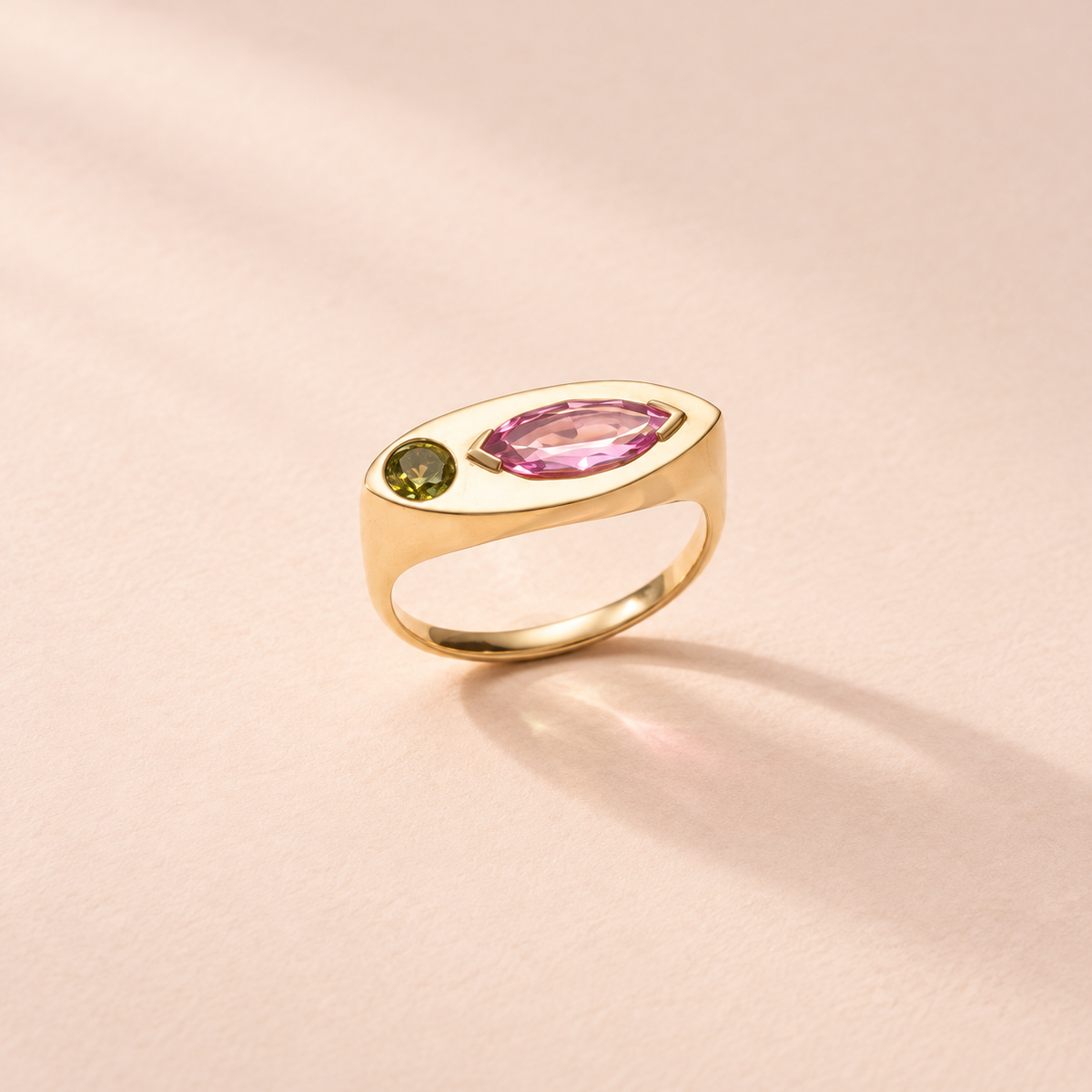 Kitty Cat collection, showcasing lost-wax cast technique in 18k yellow gold ring with fancy marquise pink sapphire and green peridot accents.