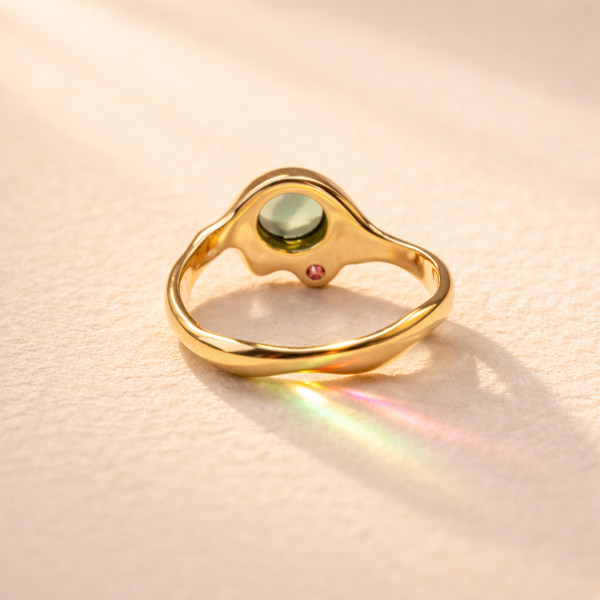 Le Drip Ring no. 05 back view showcasing a stunning green oval tourmaline set in 18k yellow gold with a pink sapphire. A true Ruinette artisan masterpiece.
