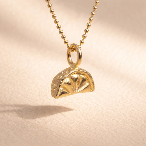 Ruinette Lemon Slice Charm close-up showing 18k yellow gold dome design with radial pattern and granulated texture on ball chain necklace